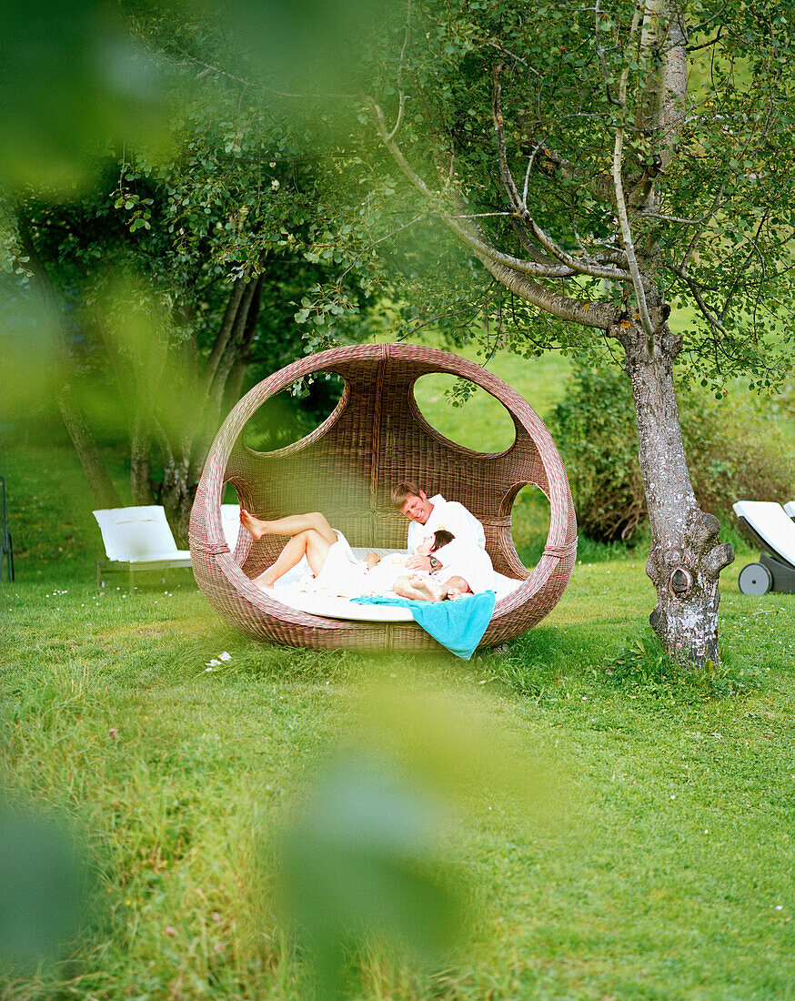 Paar entspannt sich im Garten, Naturhotel Chesa Valisa, Hirschegg, Kleinwalsertal, Österreich