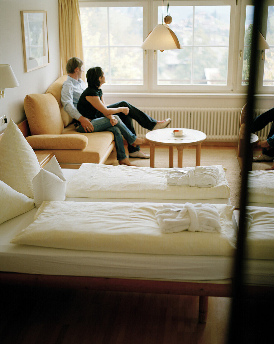 Couple relaxing in the hotel room of organic Hotel Chesa Valisa, Hirschegg, Kleinwalsertal, Austria