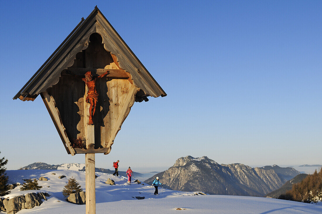 Wegkreuz und Menschen beim Schneeschuhlaufen, Eggenalm, Chiemgau, Reit im Winkl, Bayern, Deutschland, Europa