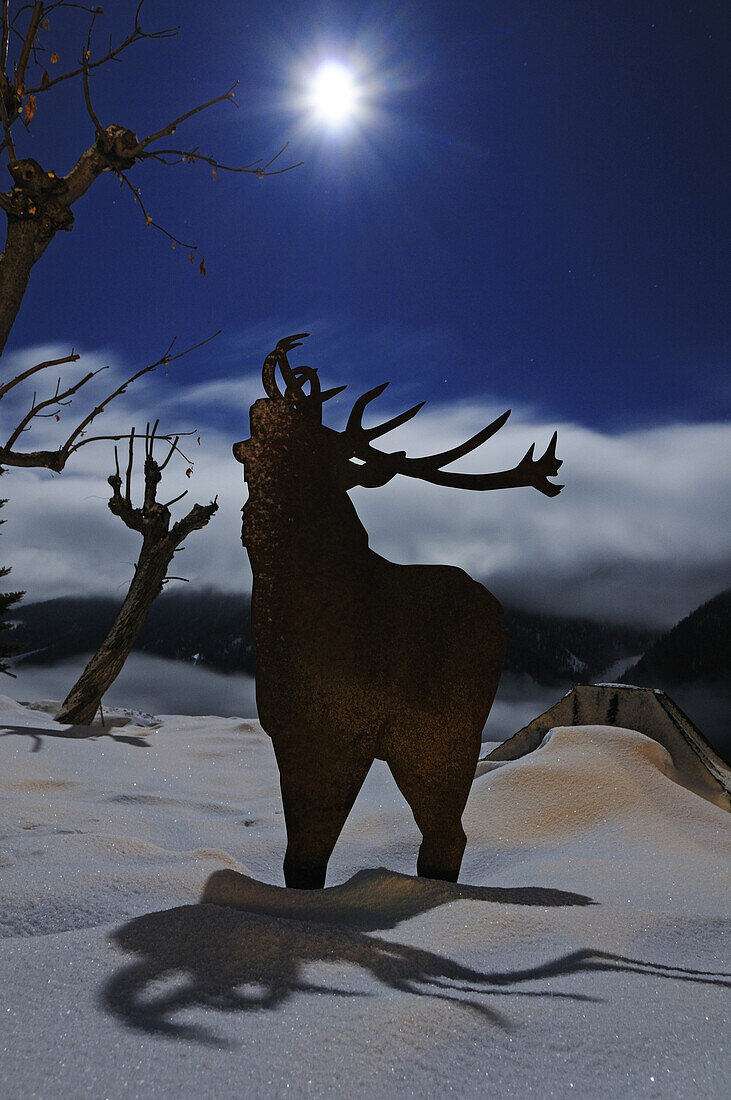 Deer figure in the snow at full moon, Hotel Meisser, Guarda, Engadin, Grisons, Switzerland, Europe