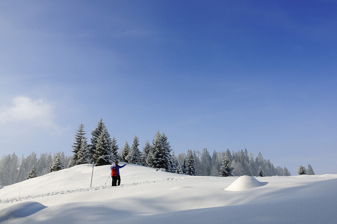 Menschen wandern auf Winterwanderweg in verschneiter Landschaft, Hemmersuppenalm, Reit im Winkl, Chiemgau, Bayern, Deutschland, Europa