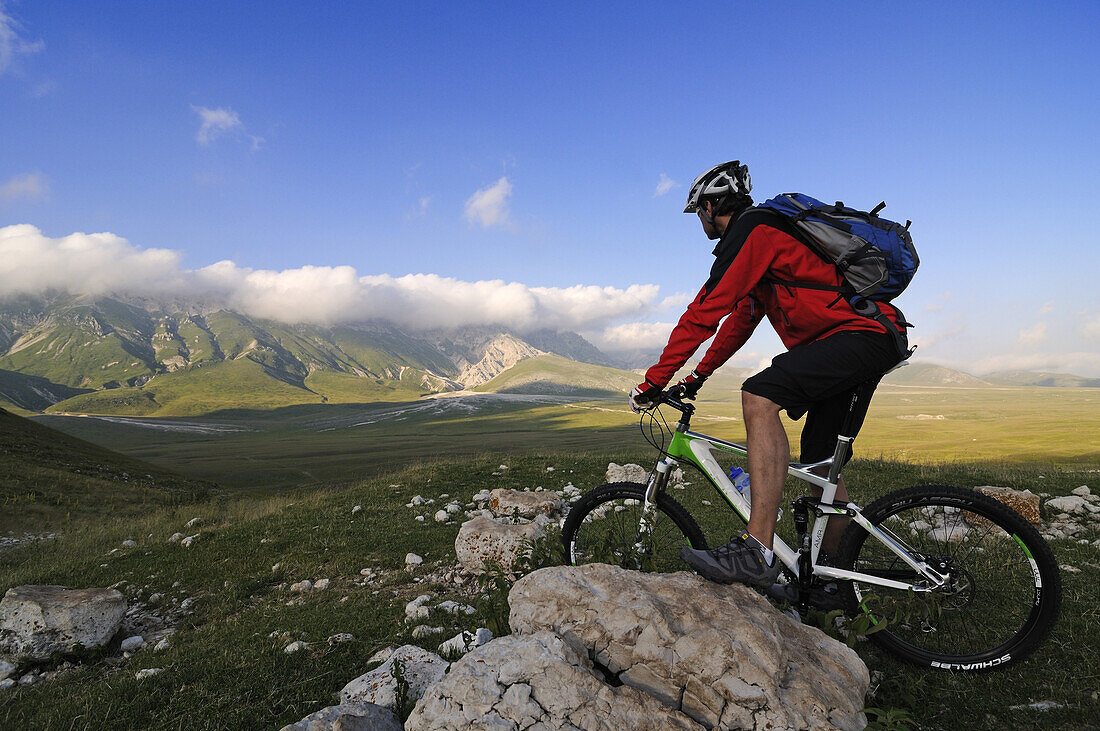 Mountainbiker betrachtet Aussicht bei Scindarella, Campo Imperatore, Gran Sasso Nationalpark, Abruzzen, Italien, Europa