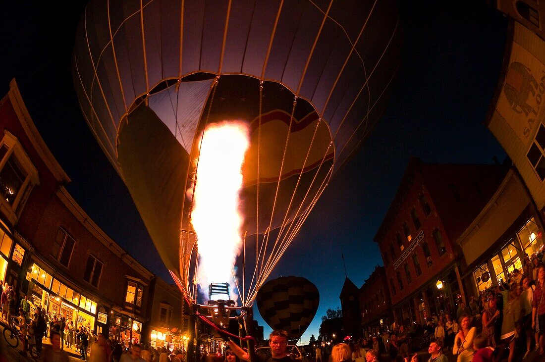 Hot air balloons illuminated at night by their propane burners, Telluride Balloon Festival, Main Street, Telluride, Colorado USA
