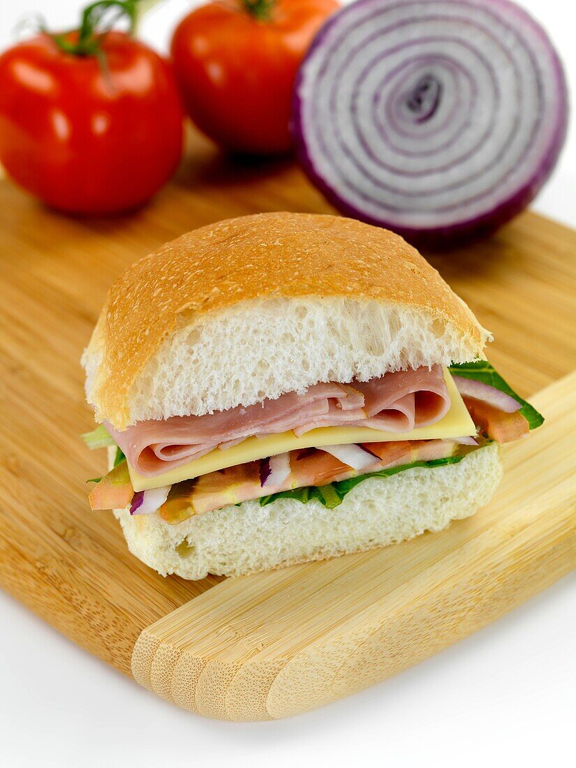 A ham and salad roll isolated against a white background