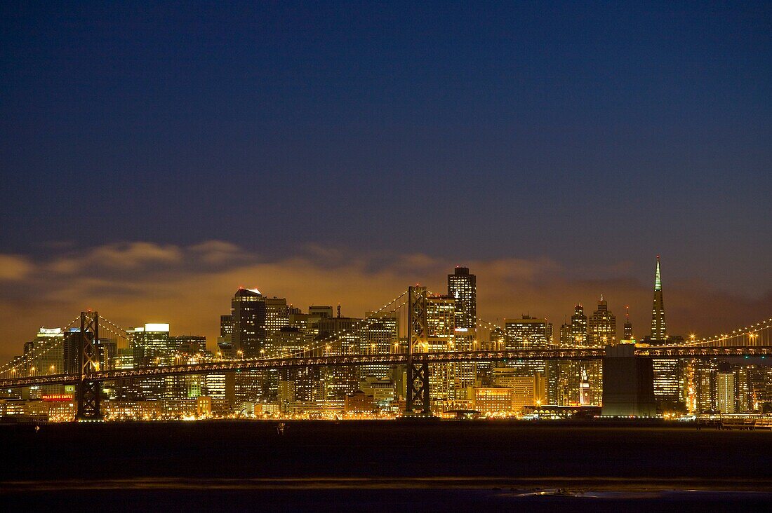 USA, California, San Francisco city skyline from Middle Harbor Park in the Port of Oakland, San Francisco-Oakland Bay Bridge in front, dusk