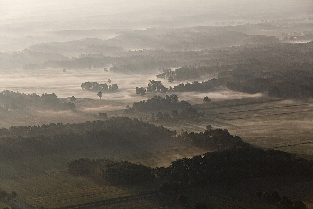Aerial of a North German landscape in the morning mist, near Lueneburg and Uelzen, Lower Saxony, Germany