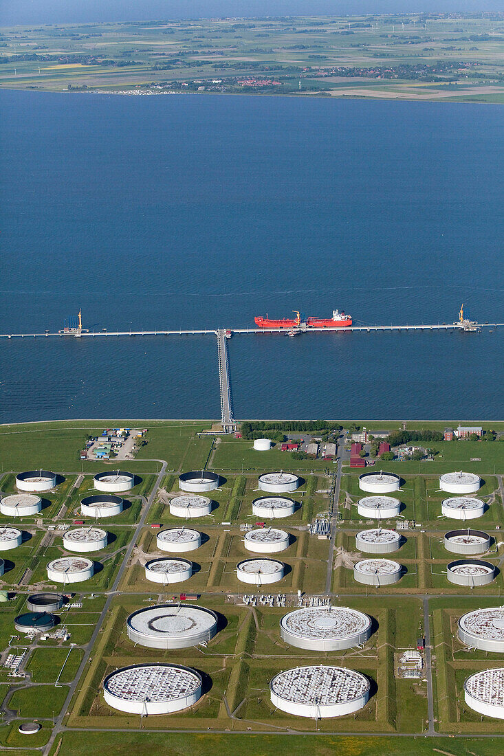 Aerial shot of oil tanker at oil pier, oil tanks in foreground, Wilhelmshaven, Lower Saxony, Germany