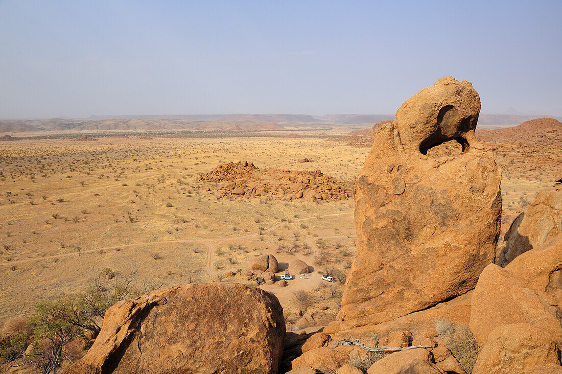 Roter Felsturm steht über Savanne mit kleinem Campingplatz, Moweni Campsite, Damaraland, Namibia