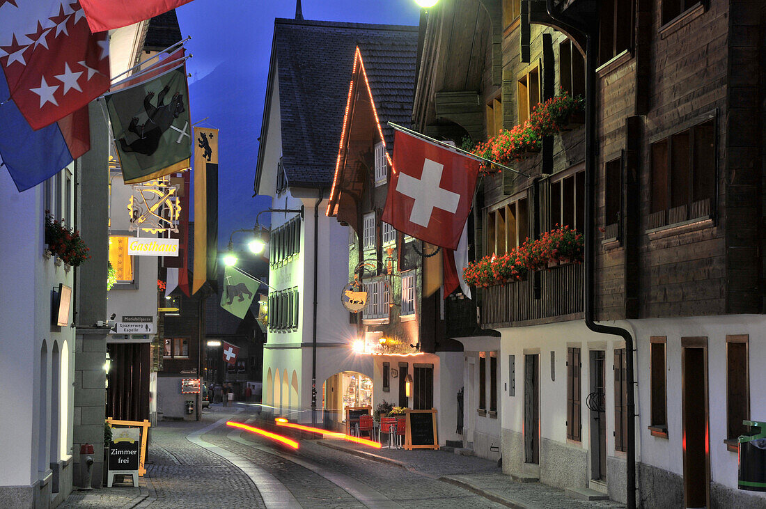 Häuser mit Fahnen bei Nacht, Andermatt, Uri, Schweiz