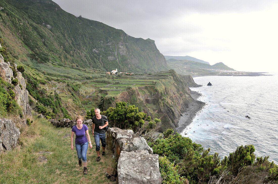Two hikers at west coast, Island of Flores, Azores, Portugal, Europe