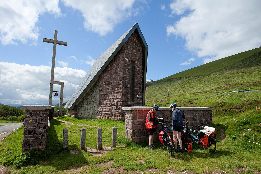 Pilgrims with bicycles in front of a chapel, Puerto de Ibaneta, Pyrenees, Province of Navarra, Northern Spain, Spain, Europe