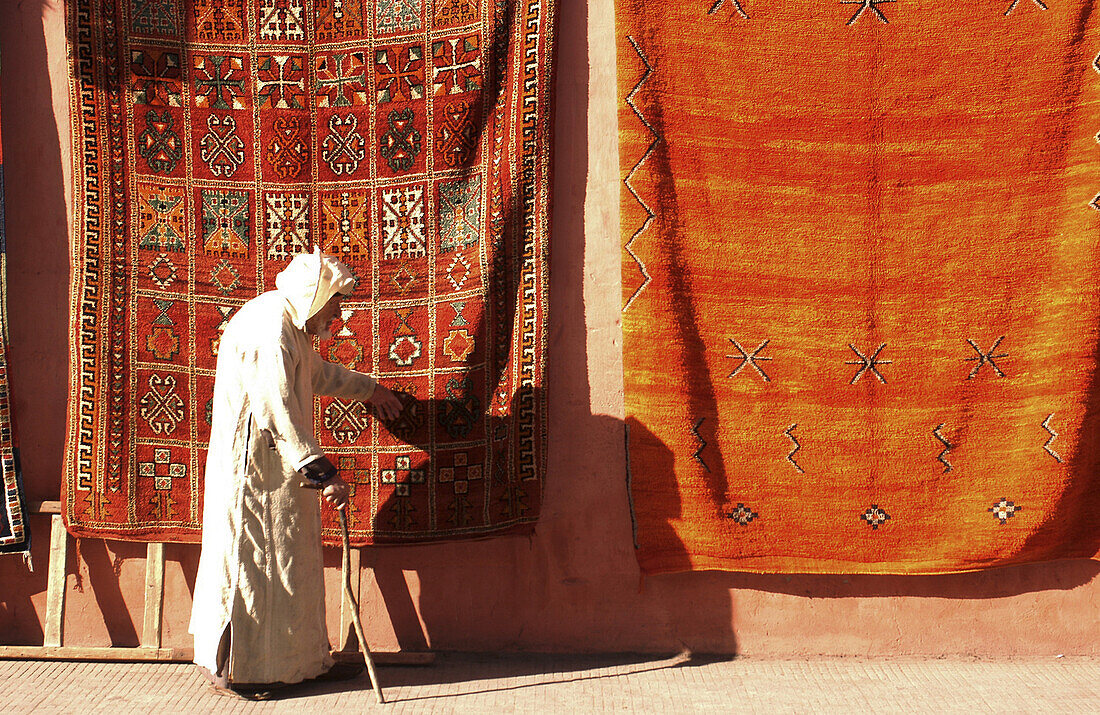 old man walking in front of carpets, Marrakech, Morroco, Africa