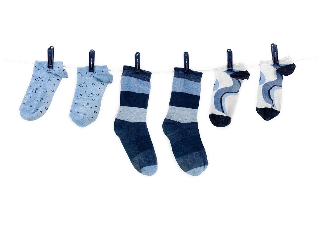 Socks hanging from a clothes line isolated against a white background