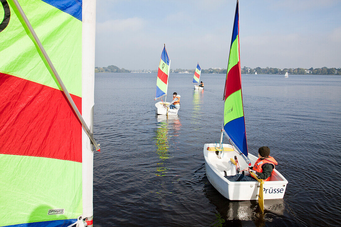 Children in sailing dinghies on outer Alster, Hamburg, Germany