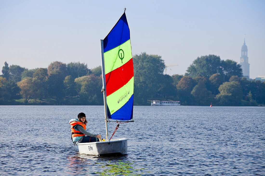Mädchen segelt in einer Jolle Optimist auf der Außenalster, Hamburg, Deutschland