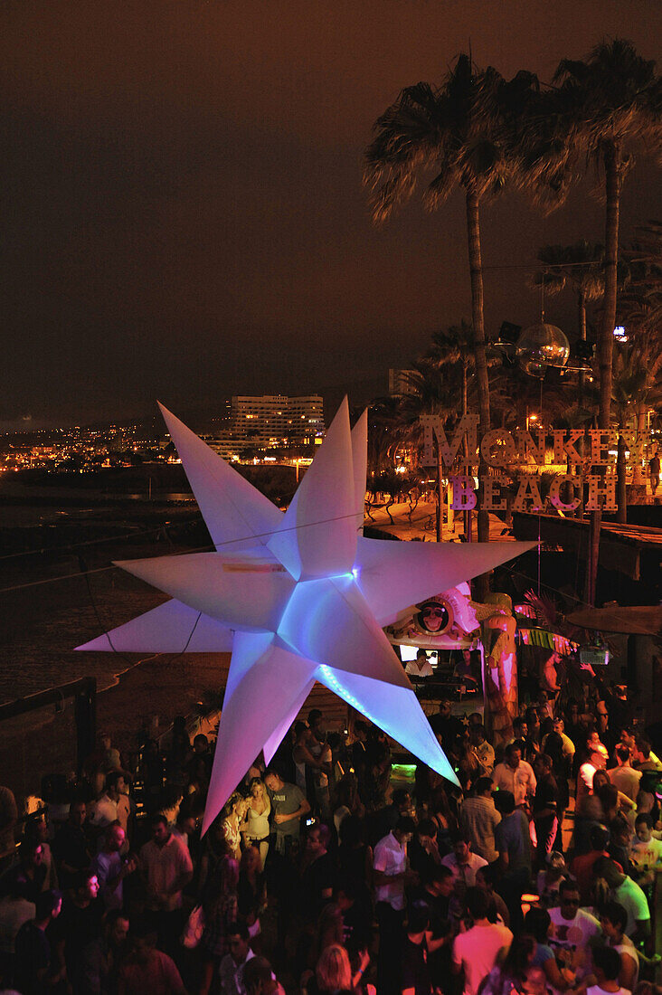 Visitors dance at sundown in the disco at Monkey Beach, Playa de las Americas,  South  Tenerife, Spain