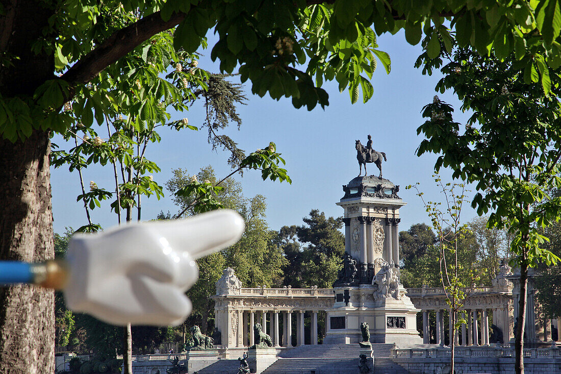 Hand Held Out Towards The Monument In Homage To Alphonse Xii, Parque Del Buen Retiro, Madrid, Spain