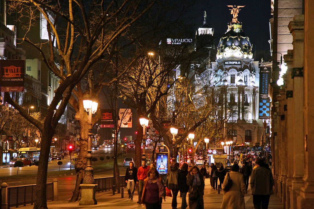 Sidewalks At Night On The Calla Alcala With The Metropolis Building Surmounted By A Bronze Statue Of The Phoenix, Madrid, Spain