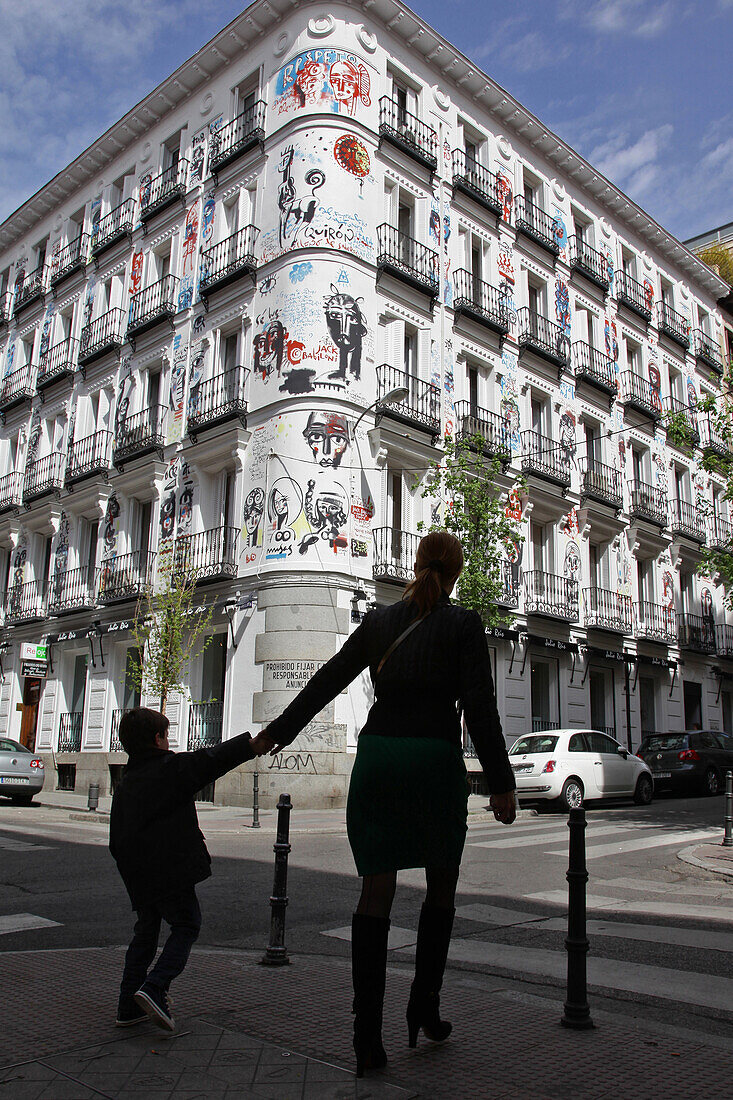 Mother And Her Child In Front Of A Painted Building On The Calle Campoamor, Chueca Quarter, Madrid, Spain