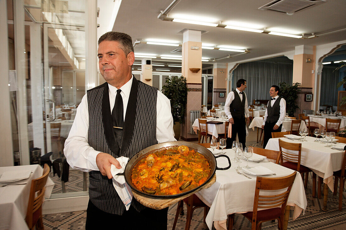 Kellner serviert Paella, Restaurant La Pepica, Provinz Valencia, Valencia, Spanien