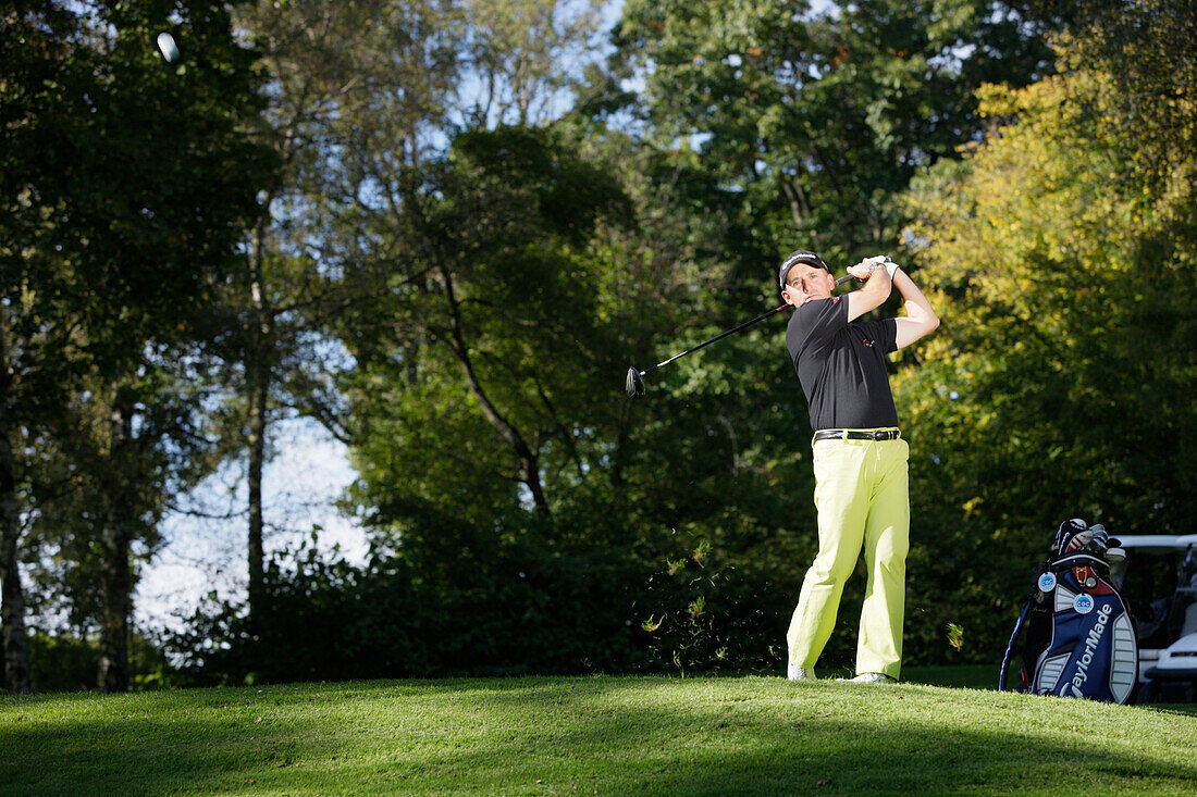 Man playing golf, Prien am Chiemsee, Bavaria, Germany