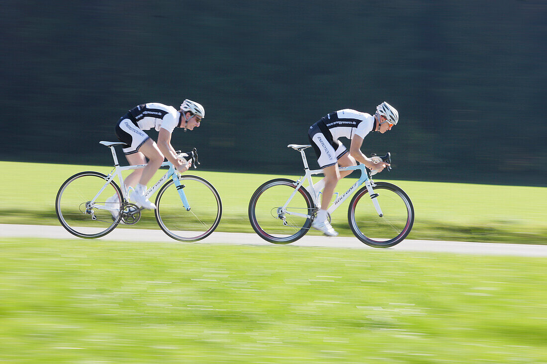 Two racing cyclists on road near Munsing, Upper Bavaria, Germany