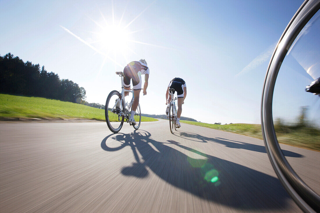 Two racing cyclists on road near Munsing, Upper Bavaria, Germany