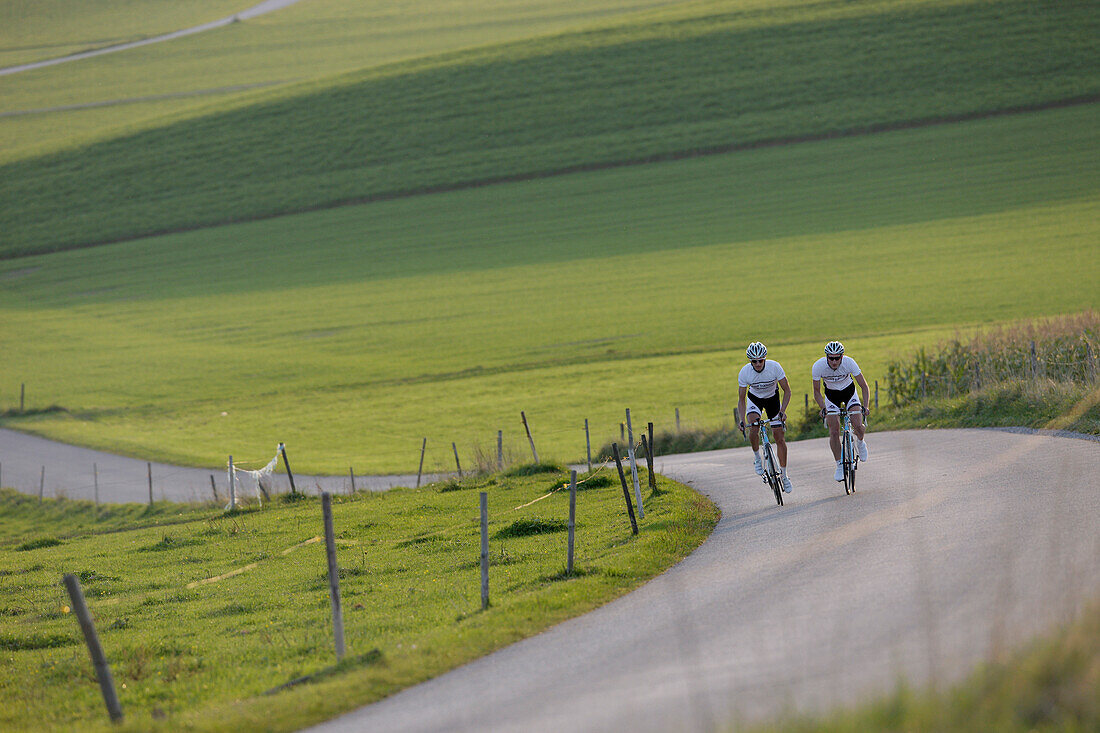 Two racing cyclists on road near Munsing, Upper Bavaria, Germany