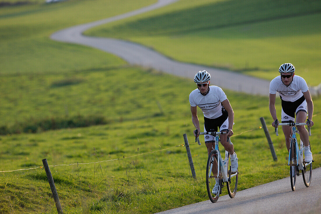 Two racing cyclists on road near Munsing, Upper Bavaria, Germany