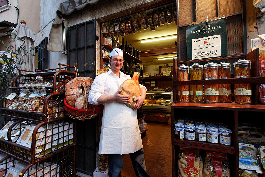 Man holding ham, Delicatessen, Torri del Benaco, Lake Garda, Veneto, Italy