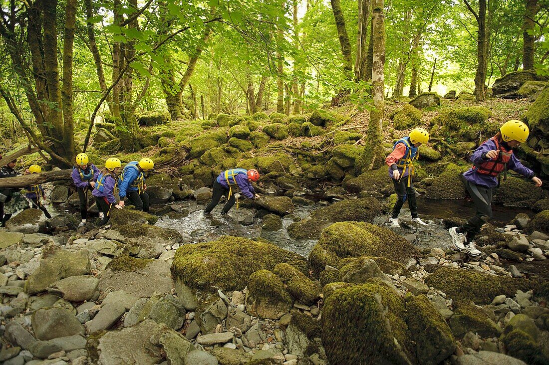 Young children walking in the River Arran near Dolgellau as part of a course organised by the Canolfan Yr Urdd outward bound adventure centre, Glanllyn, Bala, North Wales UK