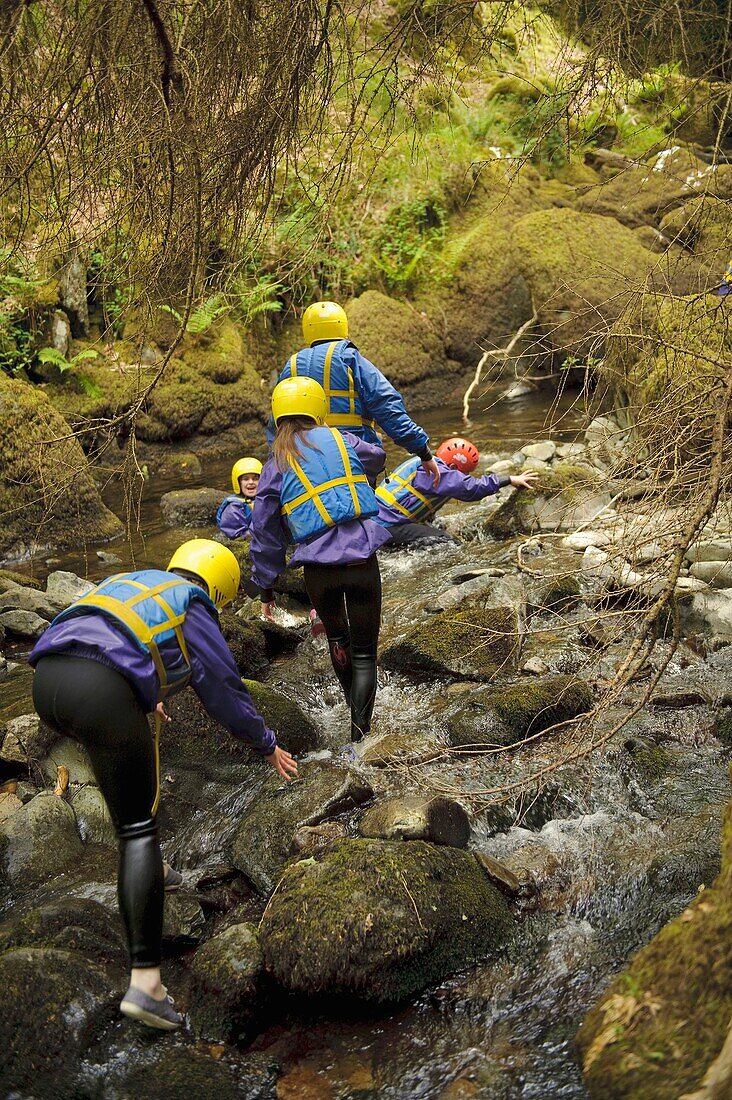 Young children walking in the River Arran near Dolgellau as part of a course organised by the Canolfan Yr Urdd outward bound adventure centre, Glanllyn, Bala, North Wales UK