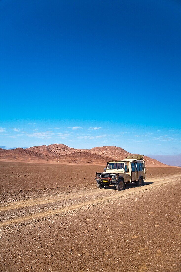 A landrover driving through the isolated Skeleton Coast Park in Namibia, Africa