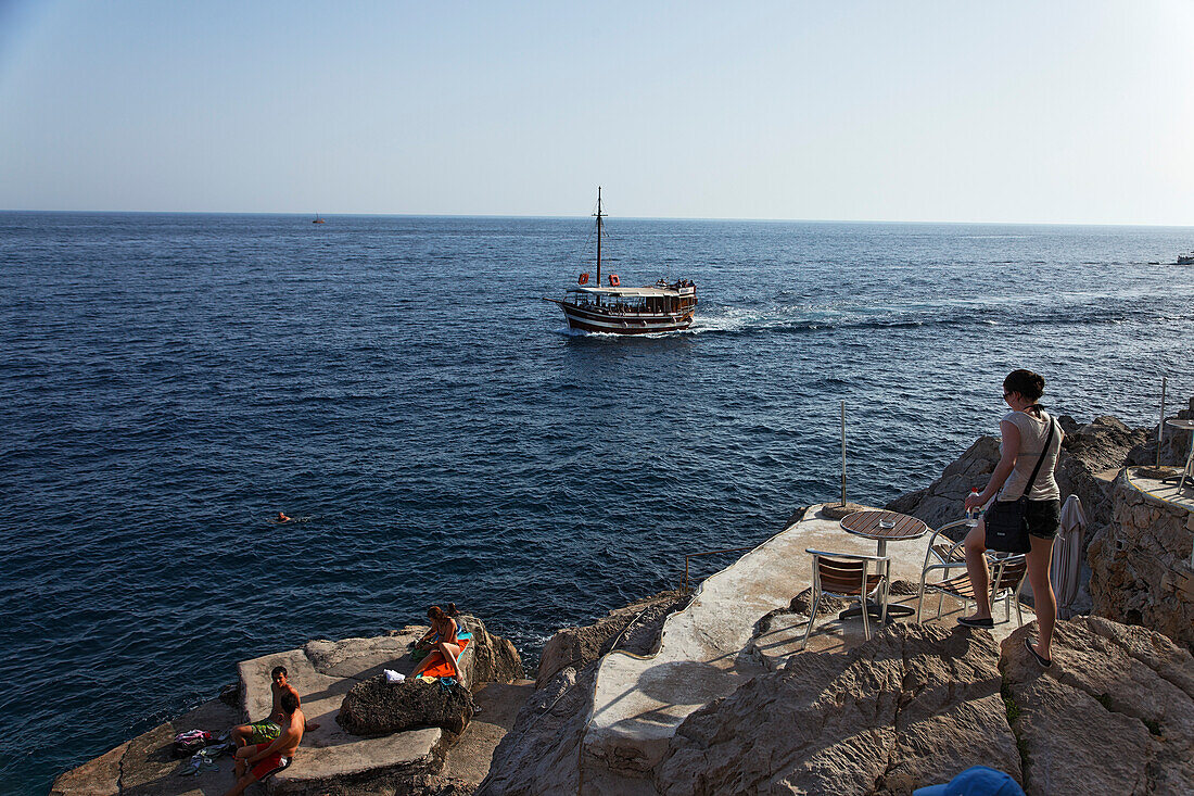 Young people sunbathing on rocks, Dubrovnik, Dubrovnik-Neretva county, Dolmatia, Croatia