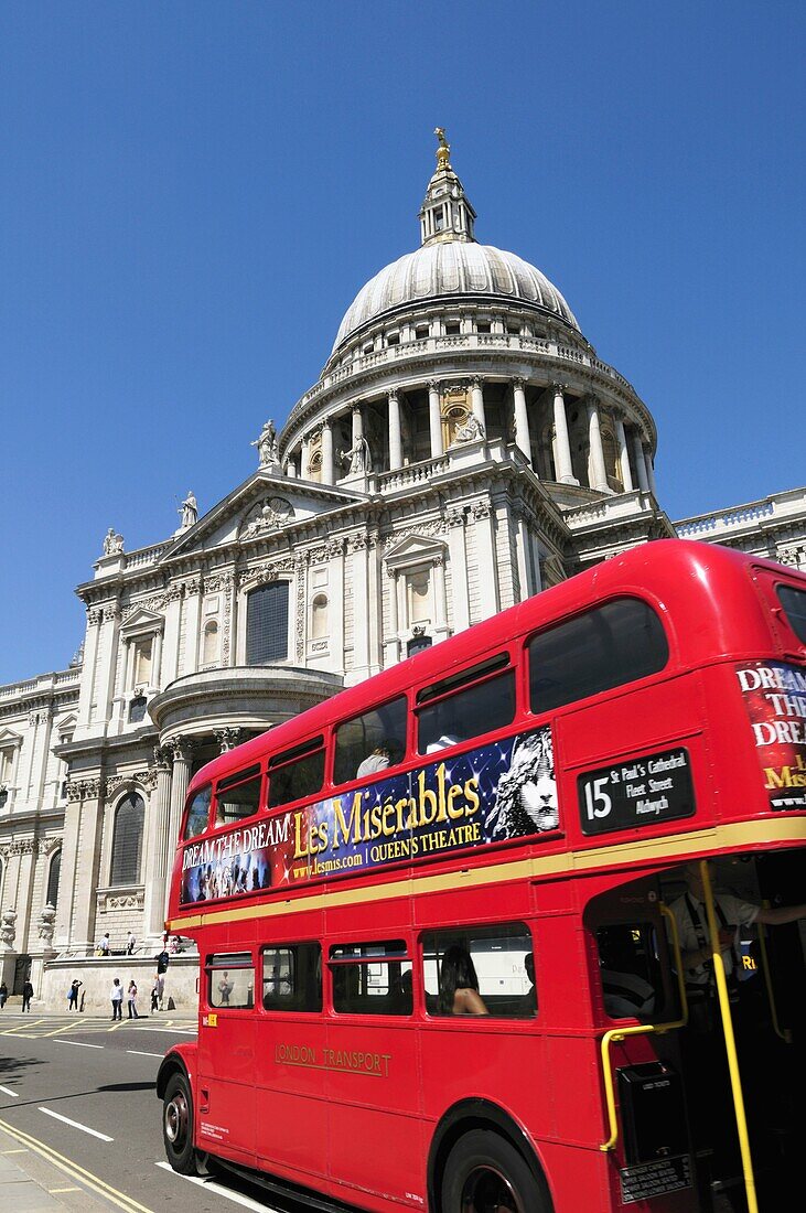 An old Routemaster double decker bus with Les Miserables advert passing St Pauls Cathedral, London, England, UK