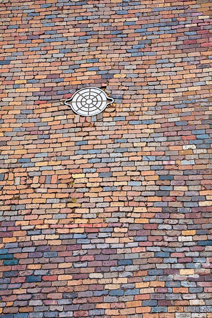 Ybor City, Tampa, FL - July 2009 - Cast iron utility handhole in colorful brick paved street at Ybor City area of Tampa, Florida