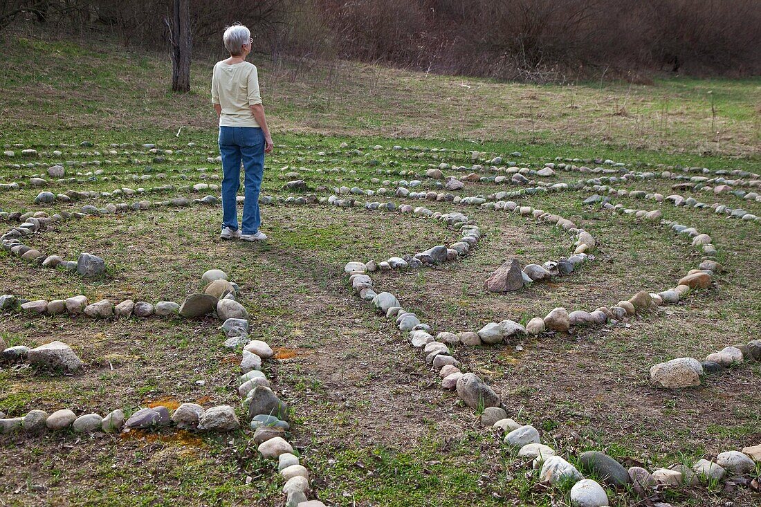 Prairieville, Michigan - A woman stands at the center of a labyrinth at Circle Pines camp The labyrinth is an aid to meditation the spiritualism © Jim West