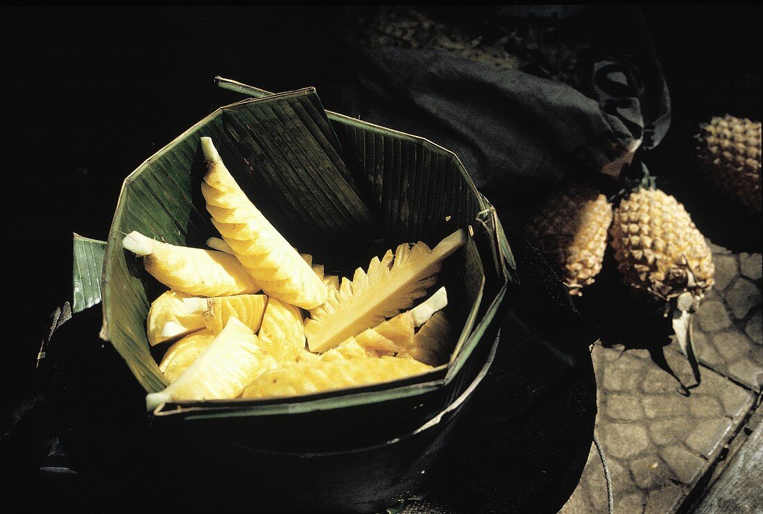 Peeled and Cut Pineapple in a Leaf Bowl