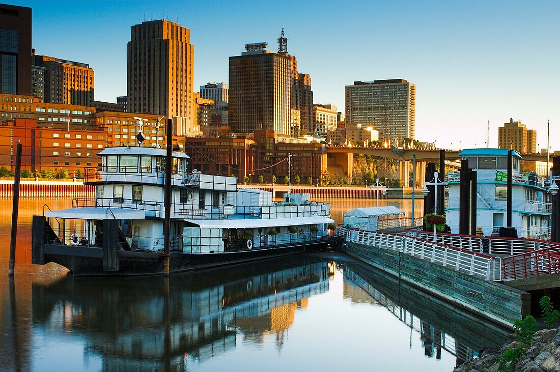 View of St Paul, Minnesota skyline and the former tugboat, now the Covington Inn Bed and Breakfast at dawn from the shore of Mississippi River