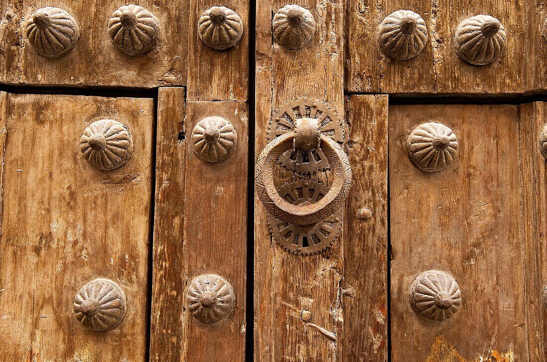 Traditional wooden door with brass knocker and ornamentation, Segovia, Spain