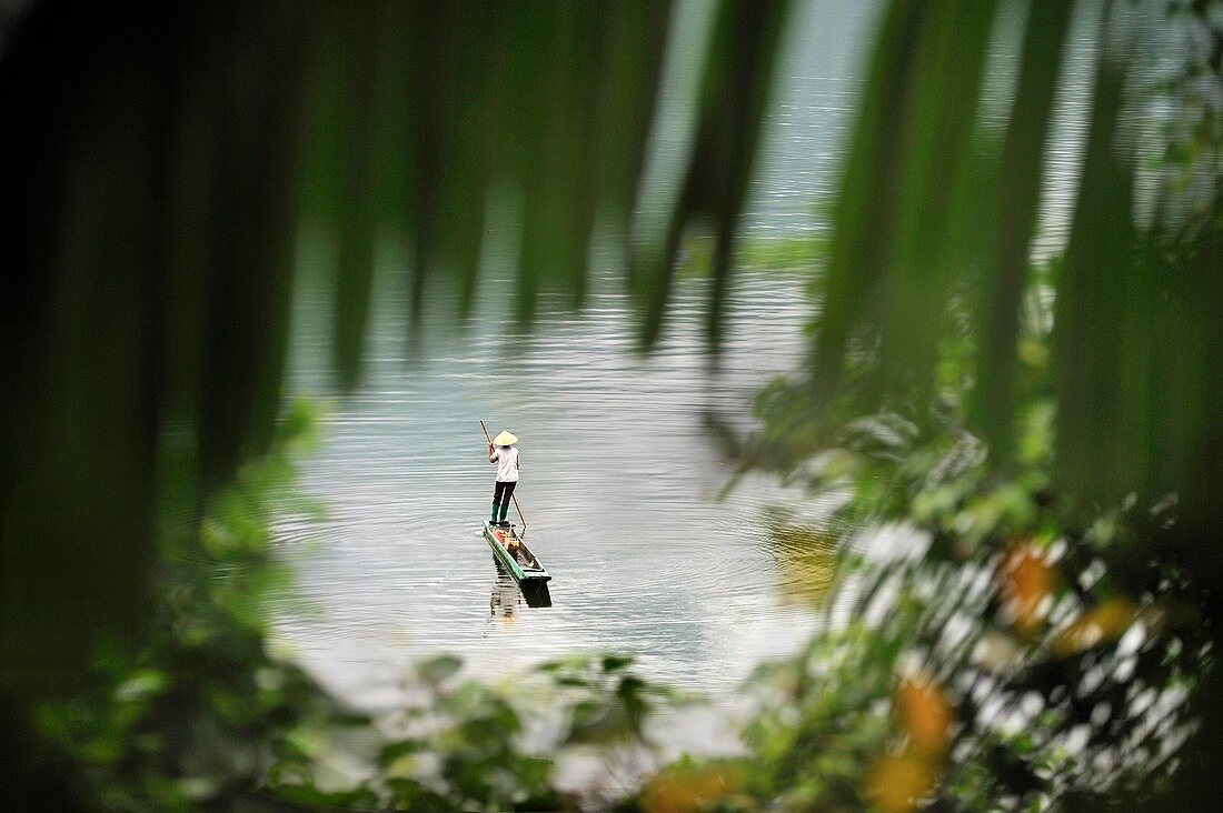 Frau beim Fischen in einer Piroge auf dem Ba Be See, Provinz Bac Kan, Nordvietnam, Südostasien