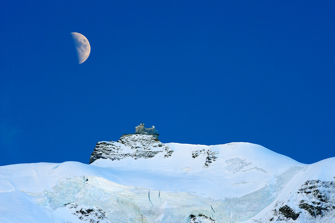 Moon above station of Jungfraujoch, Jungfrau, Grindelwald, UNESCO World Heritage Site Swiss Alps Jungfrau - Aletsch, Bernese Oberland, Bern, Switzerland, Europe