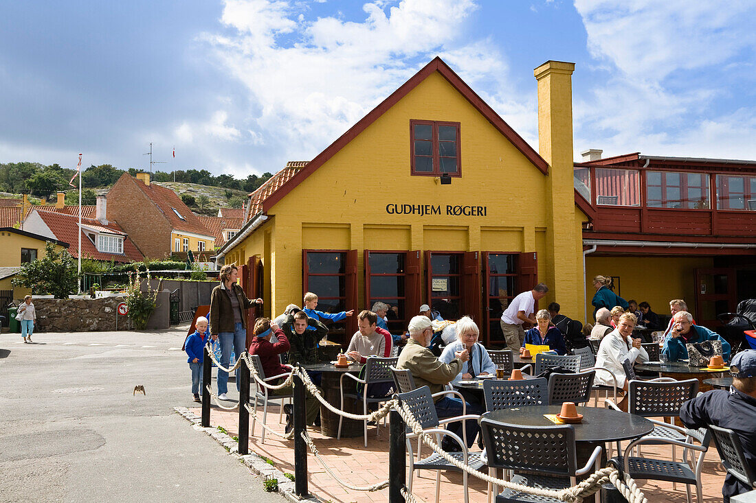 Menschen sitzen vor Heringsräucherei mit Restaurant, Gudhjem, Bornholm, Dänemark, Europa