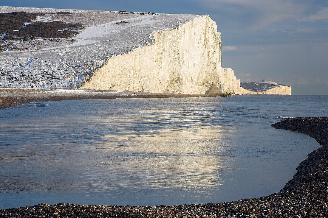 The Seven Sisters Chalk Cliffs covered in winter snow reflected in the Sea, viewed from Cuckmere Haven Sussex