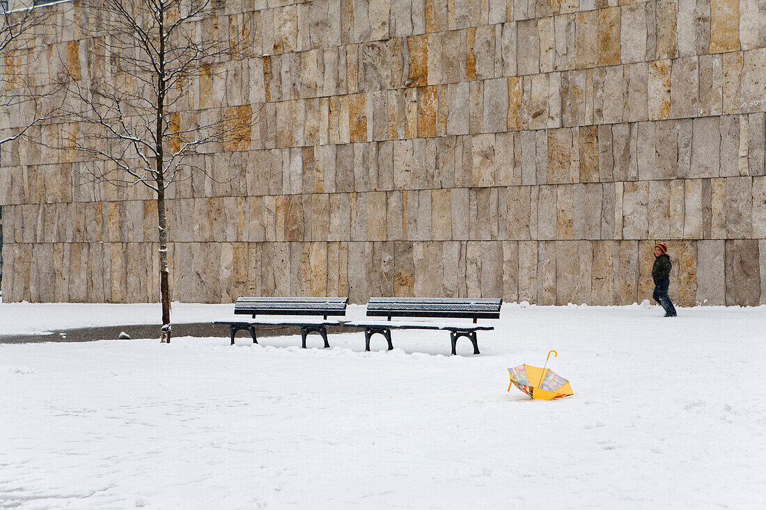 Boy in snow, umbrella in foreground