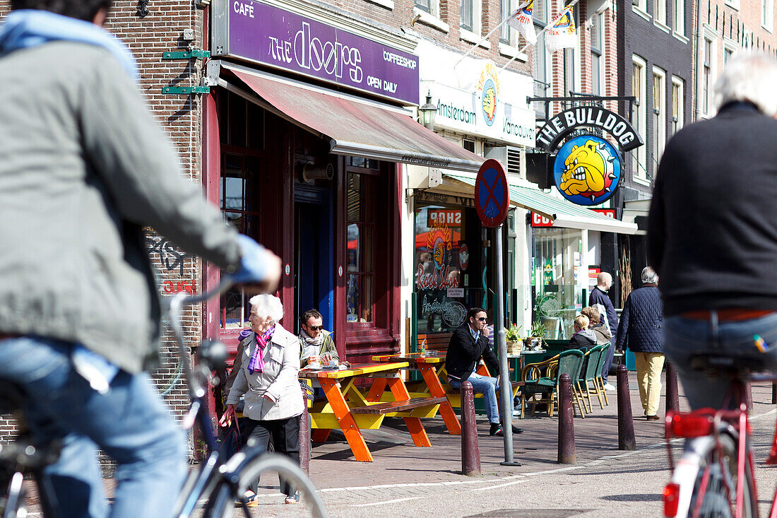 Street scene with cyclist in front of a coffee shop, Amsterdam, Netherlands