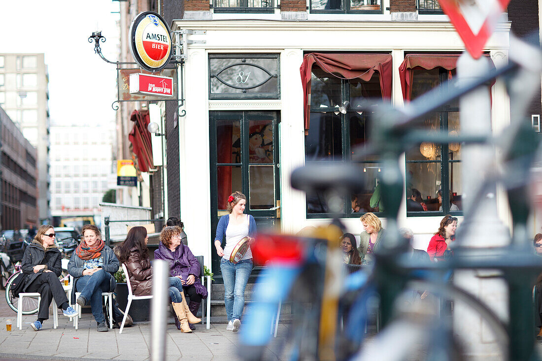 Szene mit Menschen vor einem Strassencafe in Amsterdam, Niederlande