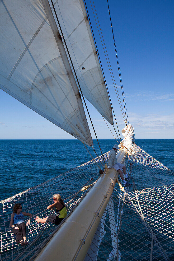 People relax on bowsprit net of sailing cruiseship Star Flyer (Star Clippers Cruises) in the Pacific Ocean near Costa Rica, Central America, America