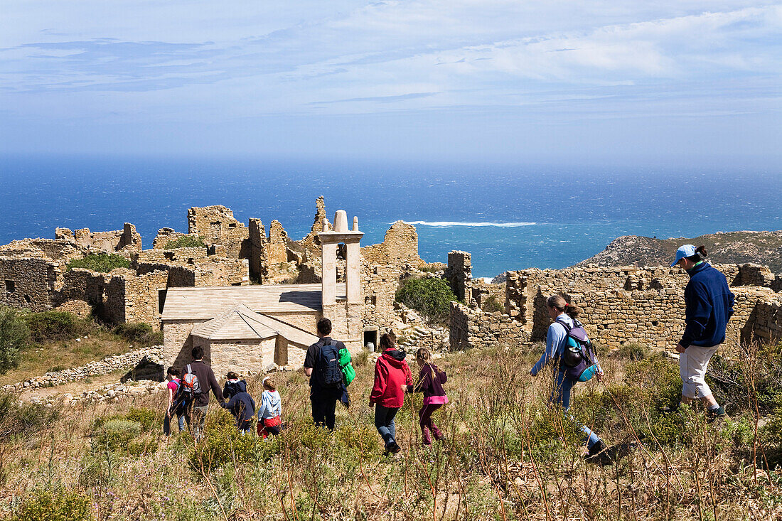 Wanderer zu den Ruinen auf dem Capo d'Occi über Algajola, Nordwest-Küste, Region Balagne, Korsika, Frankreich, Europa