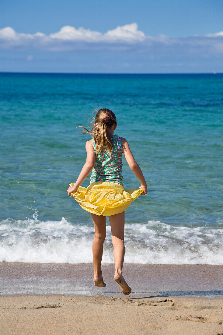 Mädchen springt am Strand, Korsika, Frankreich, Europa